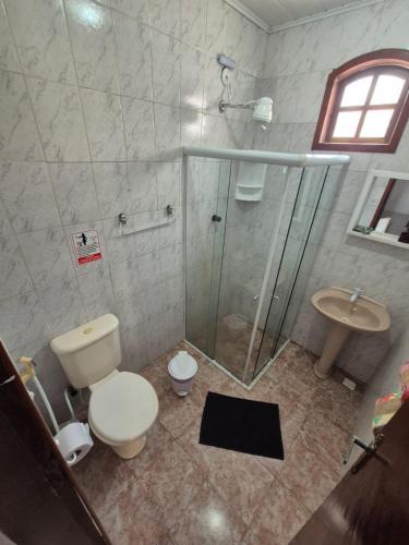 a bathroom with a shower and a toilet and a sink at Pousada Casa Da Arara suíte 104 in Saquarema
