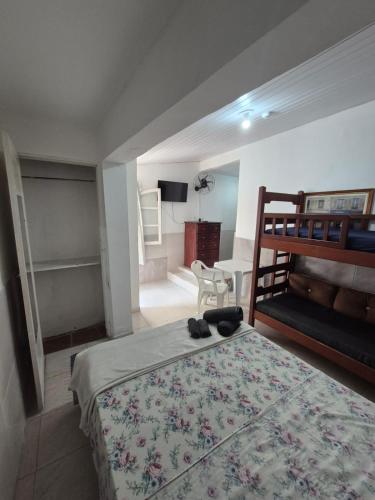 a bedroom with a bed and a desk with a chair at Pousada Casa Da Arara suíte 104 in Saquarema