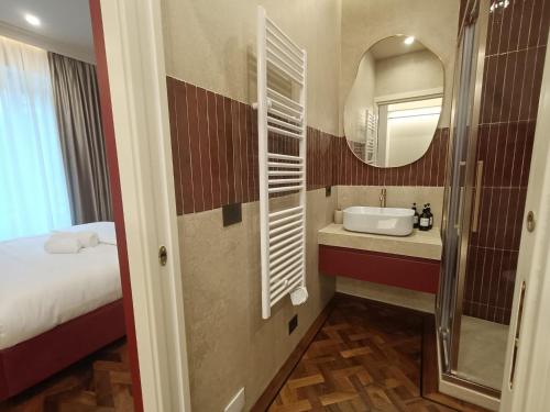 a bathroom with a bed and a sink and a mirror at Aria Domus in Lastra a Signa