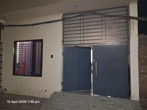 a garage with a blue door and a window at SG Homestay in Amritsar
