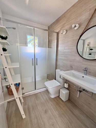 a bathroom with a toilet and a sink and a mirror at Costa Mernorca in Son Xoriguer