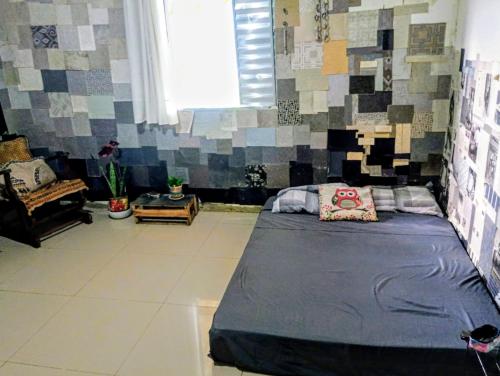 a bedroom with a bed and a wall of tiles at há uma bela casa in Ubatuba
