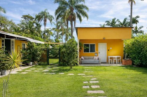 a yellow house with a lawn in front of it at Refúgio do Bosque in Penha