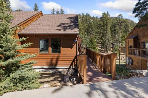 a log cabin with a staircase leading up to a house at Creekside Suites 05 by Estes Park Condos in Estes Park