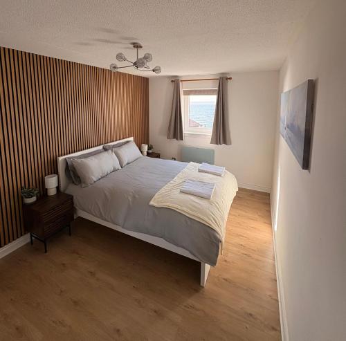 a bedroom with a large bed and a window at View of the Isles 2 in Largs