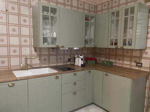 a kitchen with green cabinets and a sink at Karina in Carini
