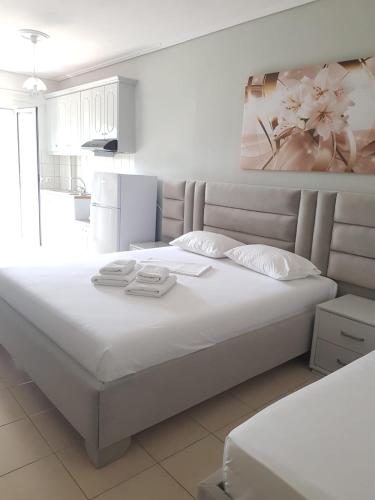 a white bed with two towels on it in a bedroom at Victoria Studio Himara in Himare