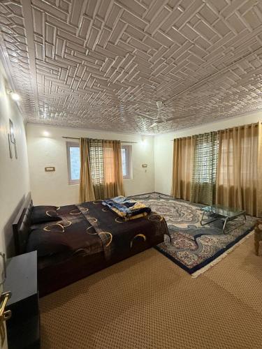 a bedroom with a large bed and a coffered ceiling at The Holt Gardens in Srinagar