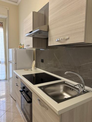 a kitchen with a sink and a stainless steel refrigerator at Casa del Corso Apartments in Avola
