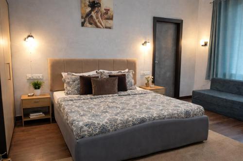 a bedroom with a bed and a blue couch at Ellara Homes in Udaipur