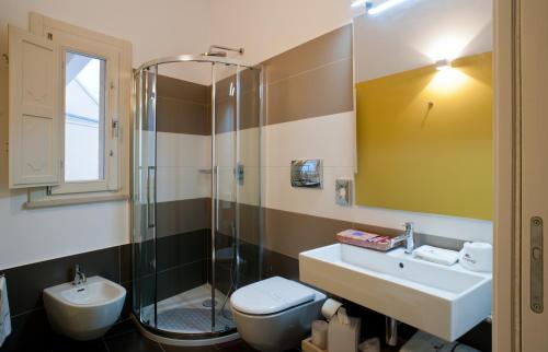 a bathroom with a sink and a shower and a toilet at Casa Majore in Chiaramonte Gulfi