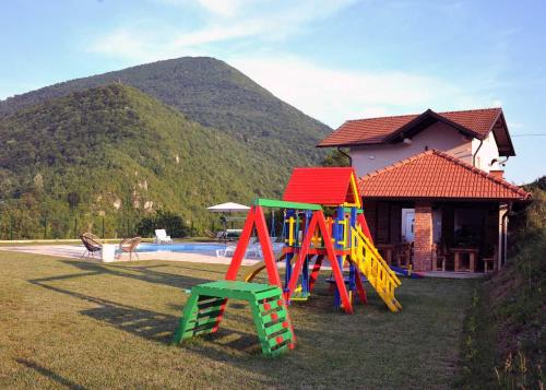 a group of colorful playground equipment in front of a house at Vikendica Danilo in Banja Luka