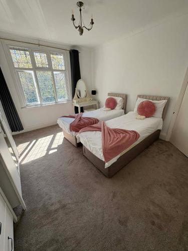 a bedroom with two beds and a window at Westmorland - 4 Bedroom House - FREE Parking for up to 7 Cars - Walking distance to QMC and University - Ideal for Contractors and Large Groups in Nottingham