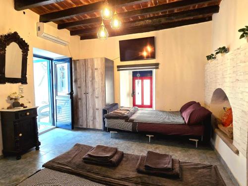 a living room with a couch and a tv at Symi Blue Studio in Symi
