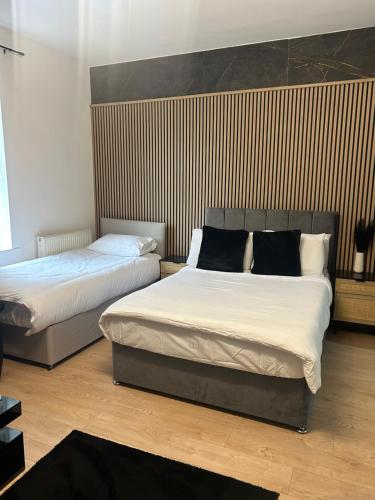 two beds in a room with two beds sidx sidx sidx sidx at Luxury rooms in Ashton under Lyne