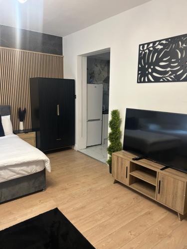 a bedroom with a bed and a flat screen tv at Luxury rooms in Ashton under Lyne