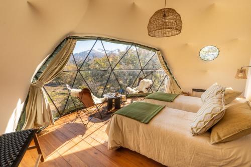 a room with a bed and a large window at Moreno Camp - Glamping with a view in El Calafate