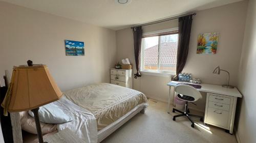a bedroom with a bed and a desk and a window at warm house2 in Coquitlam
