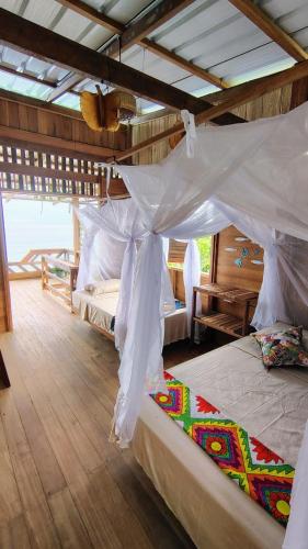 a bedroom with two beds with a canopy at cabaña malambo in Termales - agua caliente - nuqui