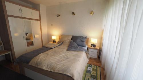 a bedroom with a large bed with two lamps on it at Apartment Alma in Zagreb