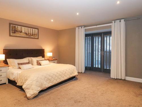 a bedroom with a bed and a large window at The Steading in Dumfries