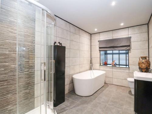 a bathroom with a tub and a shower and a sink at The Steading in Dumfries