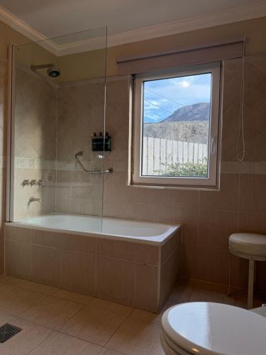 a bathroom with a bath tub and a window at Lo de Tomy in El Chalten
