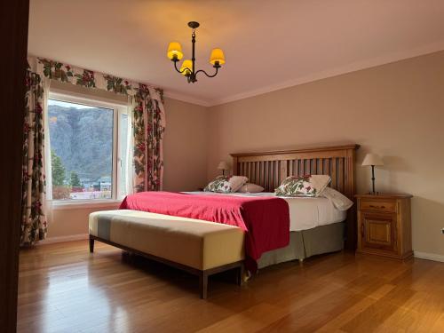 a bedroom with a bed and a window and a chandelier at Lo de Tomy in El Chalten