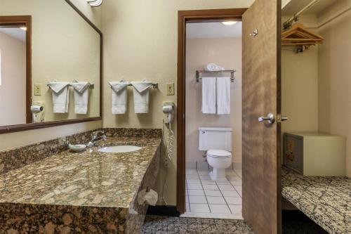 a bathroom with a sink and a toilet and a mirror at Best Western Winners Circle in Hot Springs