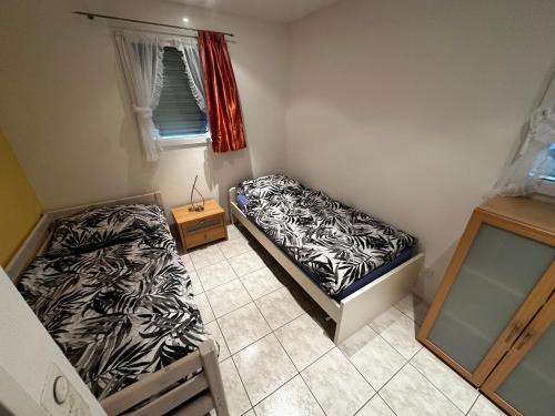 two beds in a small room with a window at HOLIDAY Residence Sette Nani in San Nazzaro