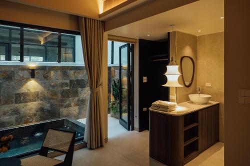 a bathroom with a tub and a sink and a mirror at Lavena Boutique Hotel in Sầm Sơn
