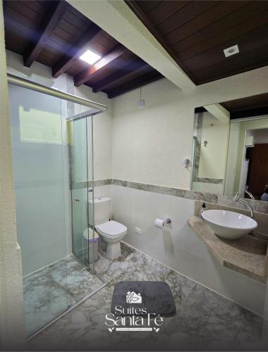 a bathroom with a glass shower and a toilet at SUITES SANTA FÉcg A5 in Campo Grande