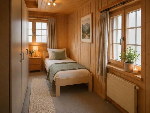 a small bedroom with a bed and a window at Ferienwohnungen Pez Regina in Lumbrein
