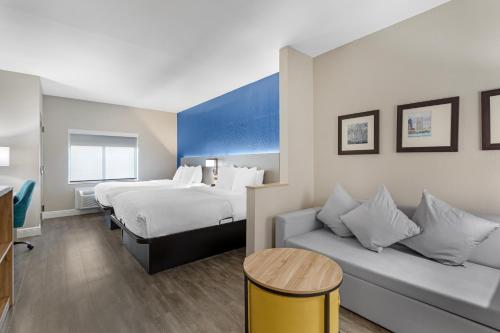 a hotel room with a bed and a couch at Comfort Suites West Jacksonville in Jacksonville