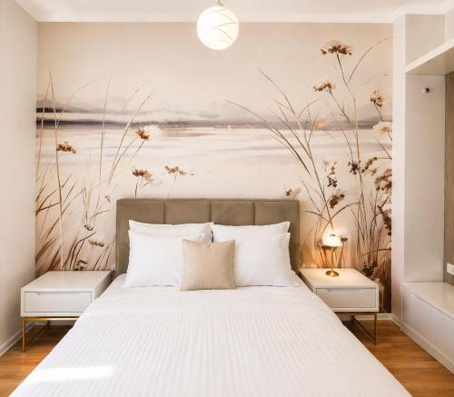 a bedroom with a bed with a painting on the wall at Viola Apartments 2 Min to Beach in Vlorë