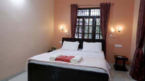 a bedroom with a bed with two towels on it at Jasmine Guest House in Majorda