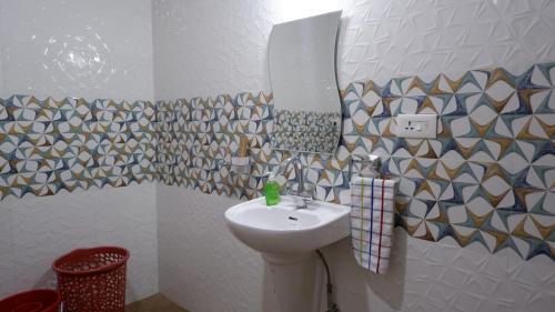 a bathroom with a sink and a mirror at Jasmine Guest House in Majorda