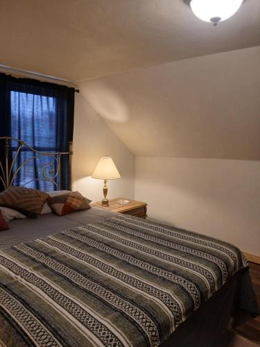 a bedroom with a bed with a lamp and a window at Aurora House in Ironwood