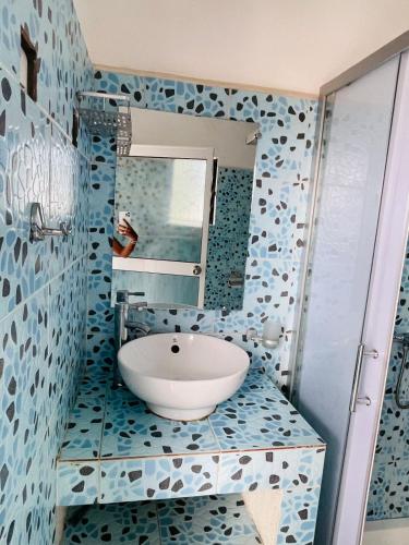 a bathroom with a sink and a mirror at Roi immo 2 in Mahajanga
