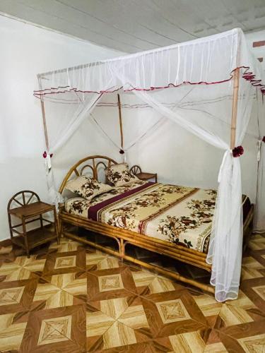 a bed with a canopy in a room at Roi immo 2 in Mahajanga