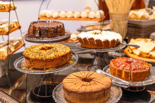 a display of cakes on trays in a bakery at Hotel Castelo Nacional Inn Campos do Jordão in Campos do Jordão