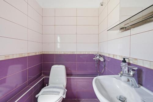 a purple and white bathroom with a toilet and a sink at Villa Deart Berat in Berat