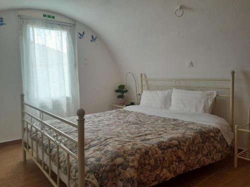 a bedroom with a bed and a window at ambelos view in Kotronas