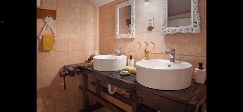 a bathroom with two sinks on a wooden counter at Jelkő Ház in Terpes
