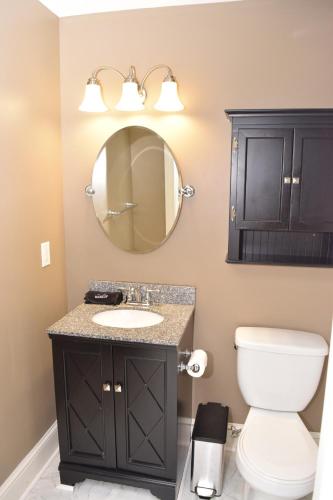 a bathroom with a sink and a mirror at Uptown Geneva Rowhouse Flat in Geneva