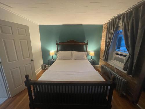a bed in a bedroom with a blue wall at Uptown Geneva Rowhouse Flat in Geneva