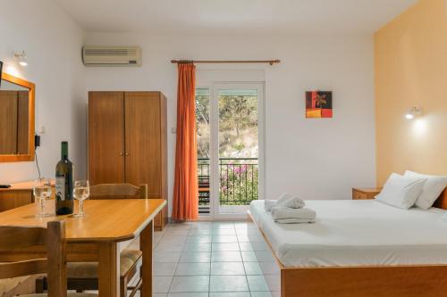 a room with a bed and a table and a dining room at Ionion Hotel in Syvota