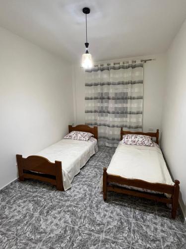 two twin beds in a room with a window at Villa Cozy in Laknas
