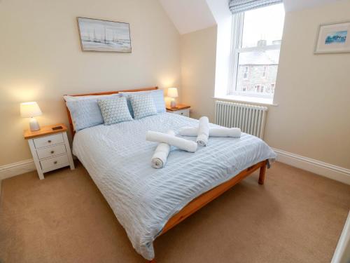 a bedroom with a bed with two towels on it at Haven Cottage in Kirkcudbright