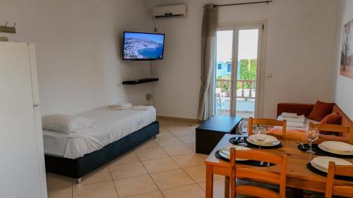 a bedroom with a bed and a dining room with a table at Ateni House in Agios Petros